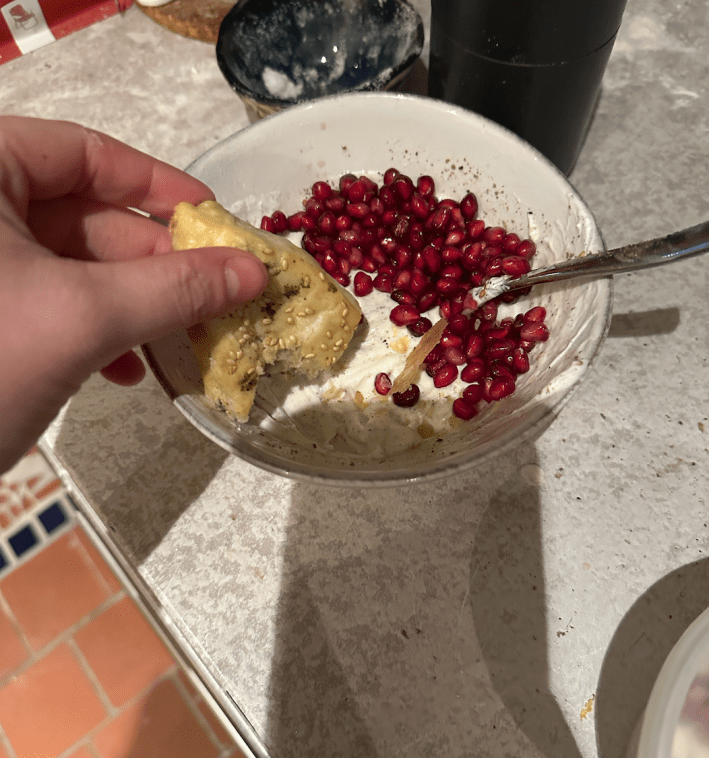 a white dip with pomagrante seeds on top